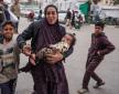 Una mujer palestina que sostiene a sus hijos reacciona frente a un hospital al que se trasladan las víctimas tras el bombardeo israelí en Bureij, en el centro de la Franja de Gaza.