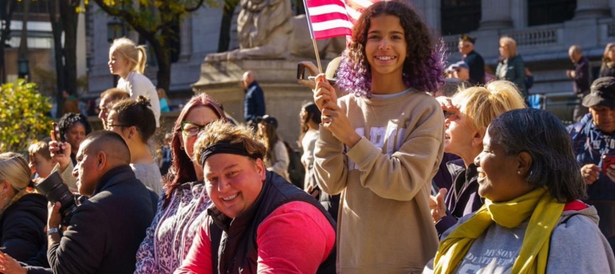 Residentes de Nueva York sonríen a la cámara durante un desfile callejero.