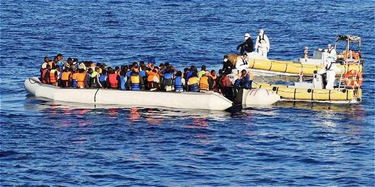 la Armada italiana muestra a varios miembros del ejército italiano mientras ayudan a decenas de inmigrantes durante una operación de rescate en el mar Mediterráneo