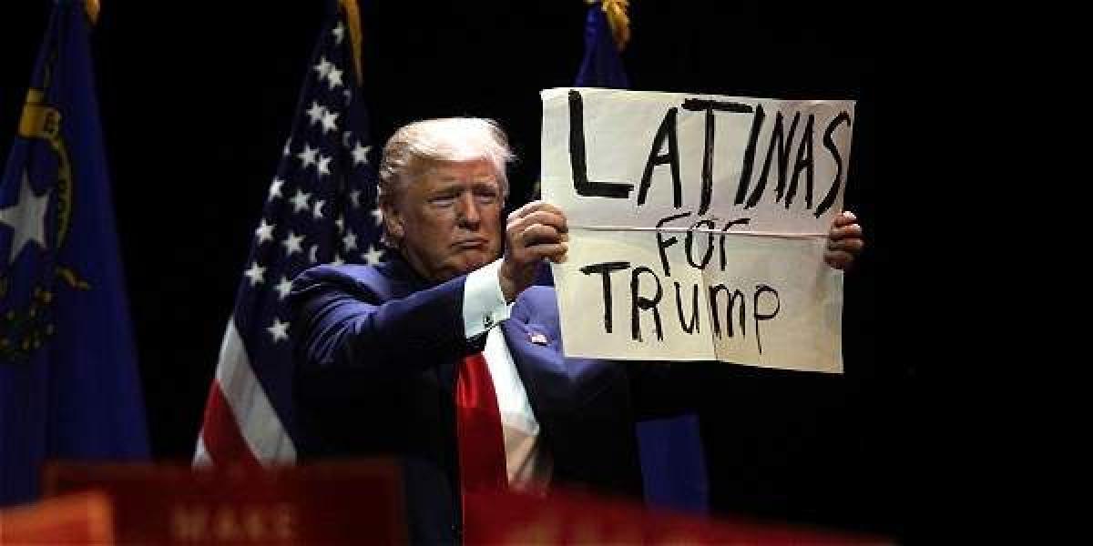 Donald Trump muestra un cartel de apoyo de mujeres latinas a su aspiración presidencial en Las Vegas.