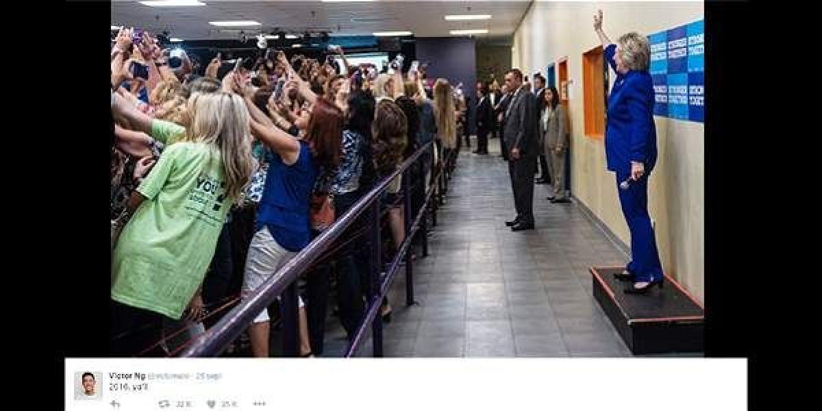 Cientos de jóvenes se asoman de espaldas a la candidata demócrata para tomarse una foto en un evento de campaña.