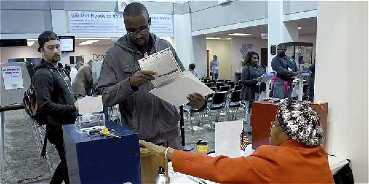 Un hombre entrega su  voto en un centro electoral en Denver, Colorado (EEUU).
