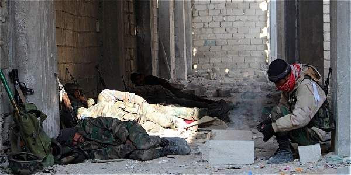 Soldados sirios descansan en una calle tras una batalla en el barrio Sheik Saeed, de Alepo.