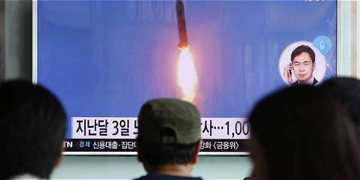 Varias personas prestan atención a un informativo en Seúl (Corea del Sur) en el que se informa del lanzamiento, por parte de Corea del Norte, de tres misiles balísticos al Mar de Japón