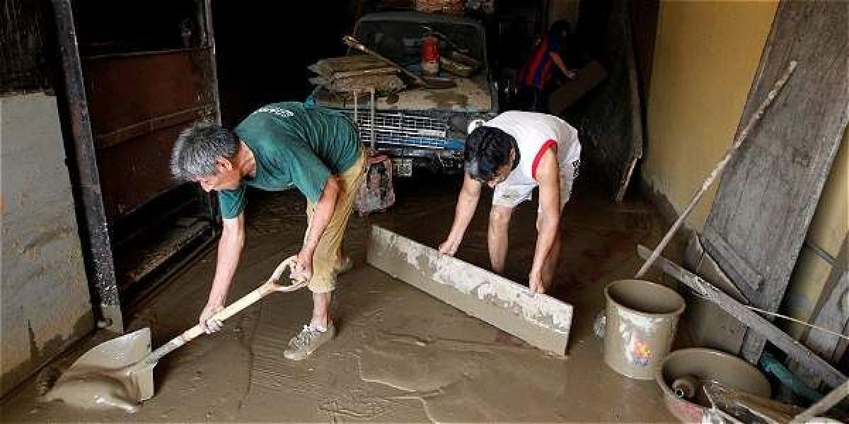 Esta pareja remueve el lodo que entró a la casa por culpa de las inundaciones que afectan la zona centra de Lima, Perú.
