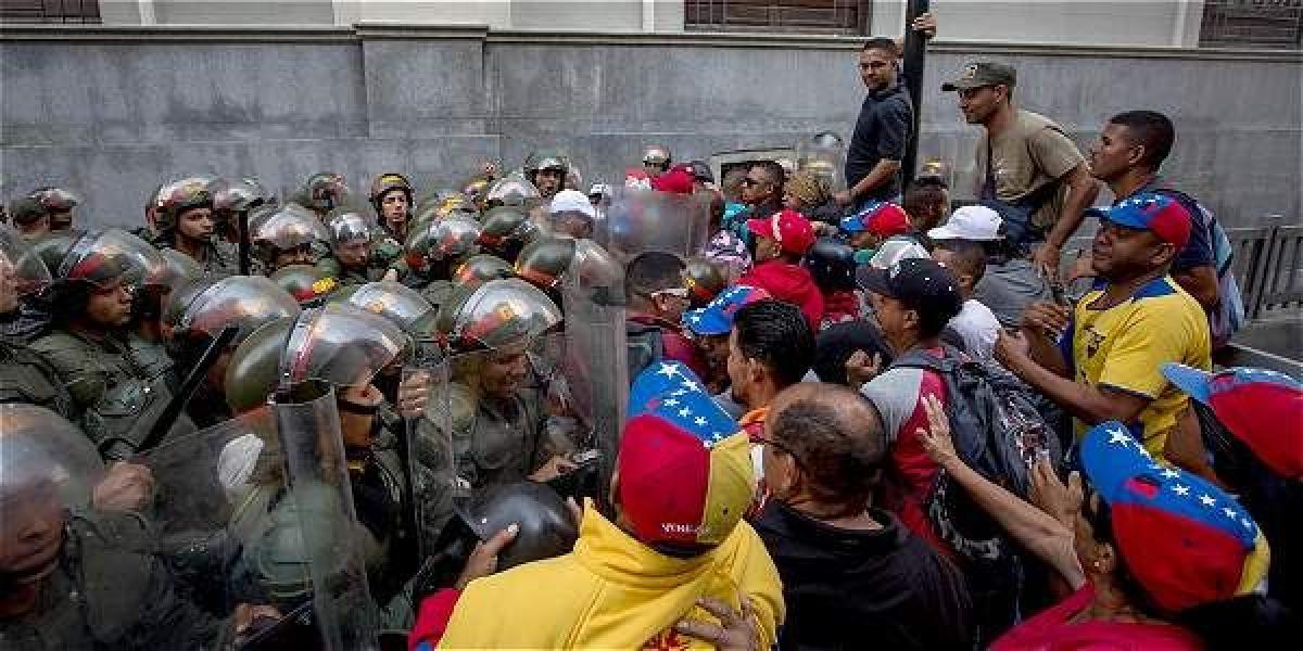 Un grupo de simpatizantes chavistas se enfrentan a miembros de la Guardia Nacional Bolivariana (GNB) en las inmediaciones del edificio de la Asamblea Nacional.