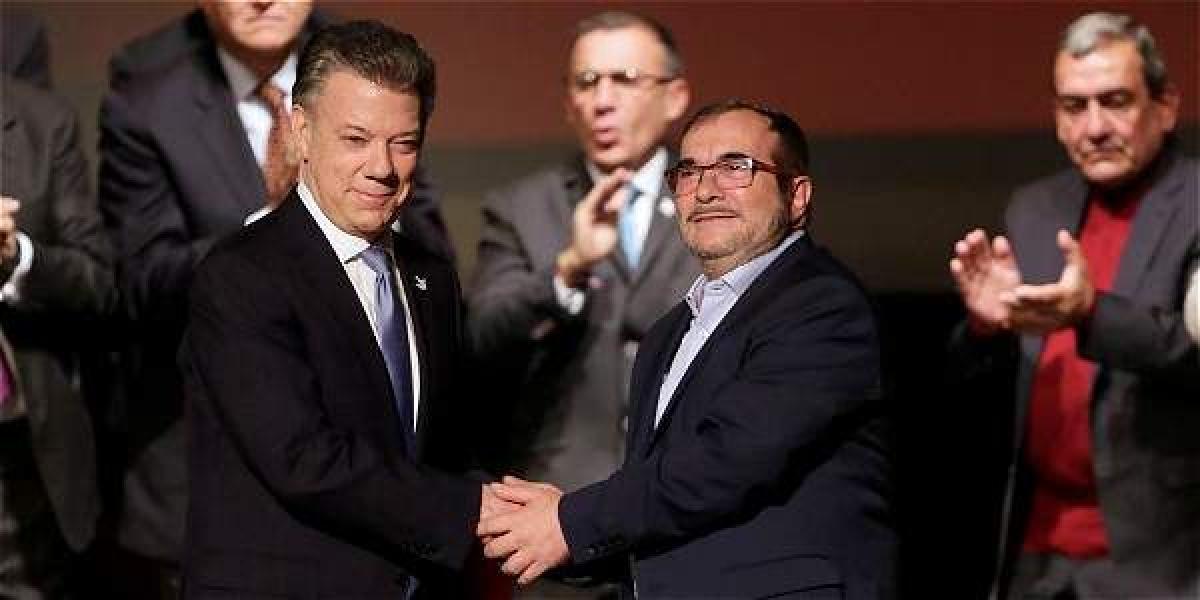El presidente Juan Manuel Santos y 'Timochenko', máximo líder de las Farc, durante la firma del nuevo acuerdo en Bogotá.