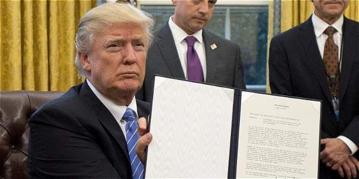 El presidente estadounidense Donald Trump muestra el documento mediante el cual su país sale del Tratado Transpacífico (TTP). Efe