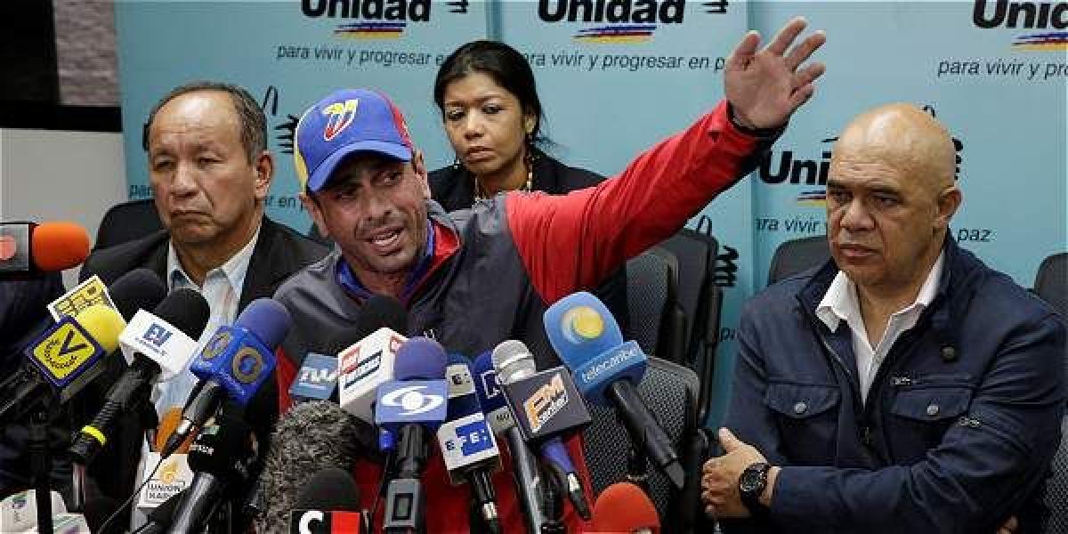 El opositor Henrique Capriles (c.) denunció que bandas armadas querían impedir que se bajara del avión al llegar a la isla Reuters