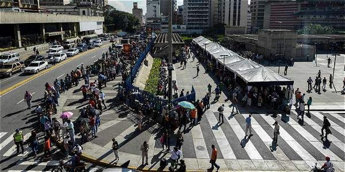 Desesperados por el retiro del mayor billete, los venezolanos hacen filas en el Banco Central para obtener infructuosamente efectivo. En algunas ciudades desataron protestas y saqueos.
