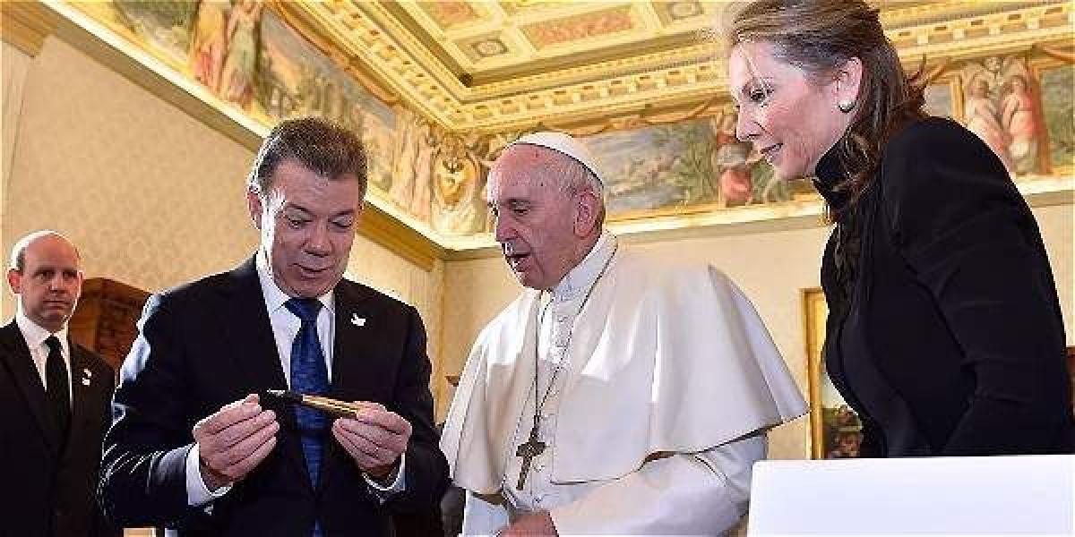 El presidente Santos le muestra un 'balígrafo' al papa Francisco. Los acompaña la esposa del mandatario, María Clemencia Rodríguez de Santos.
