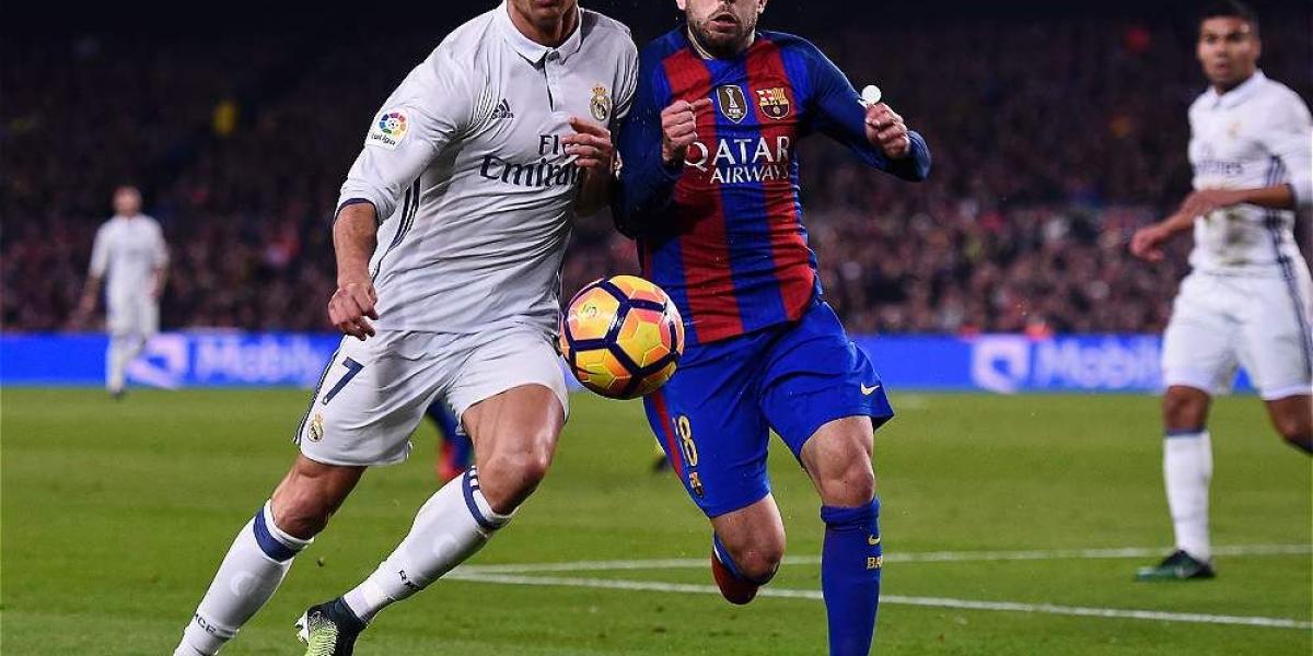 Cristiano Ronaldo y Jordi Alba disputan un balón cerca del área del Barcelona.