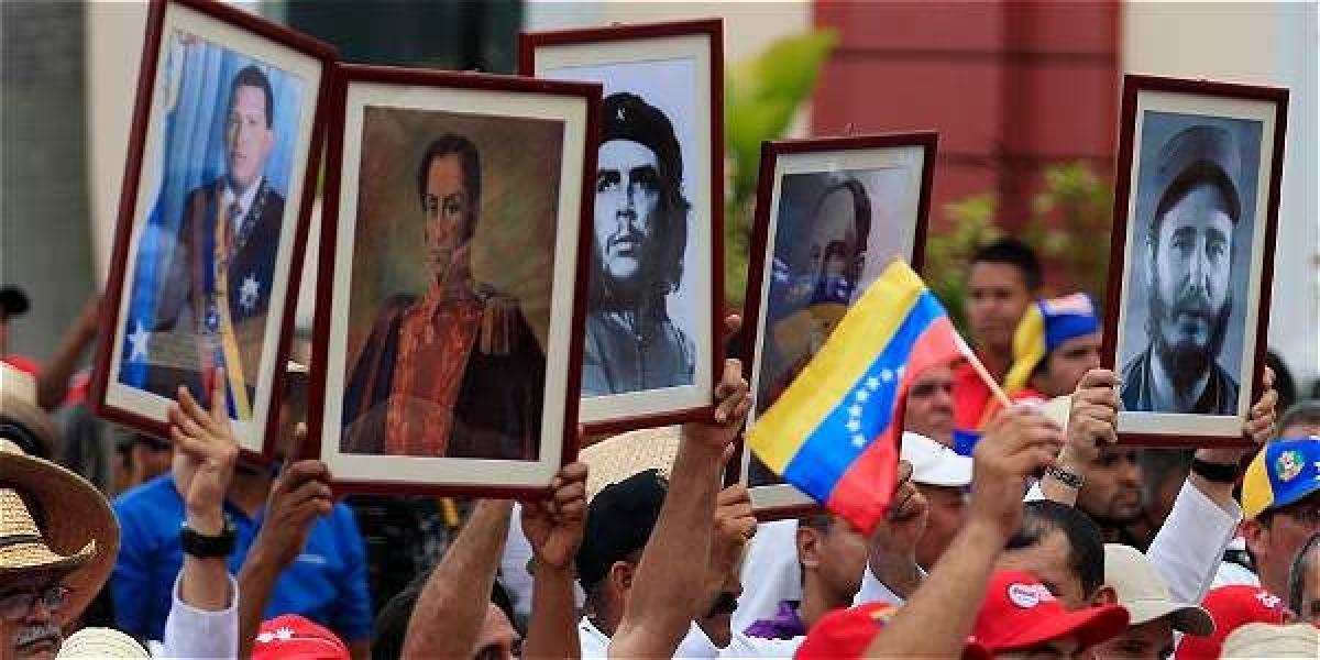 Hay muchos cubanos viviendo en Venezuela hoy. Aquí, algunos muestran imágenes de Chávez, Bolívar, Guevara, Martí y Castro en una manifestación en Caracas, en 2014.