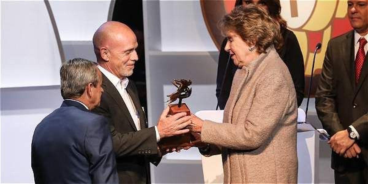Ana María Busquets de Cano entrega el premio al mérito periodístico Guillermo Cano al periodista Mauricio Gómez.