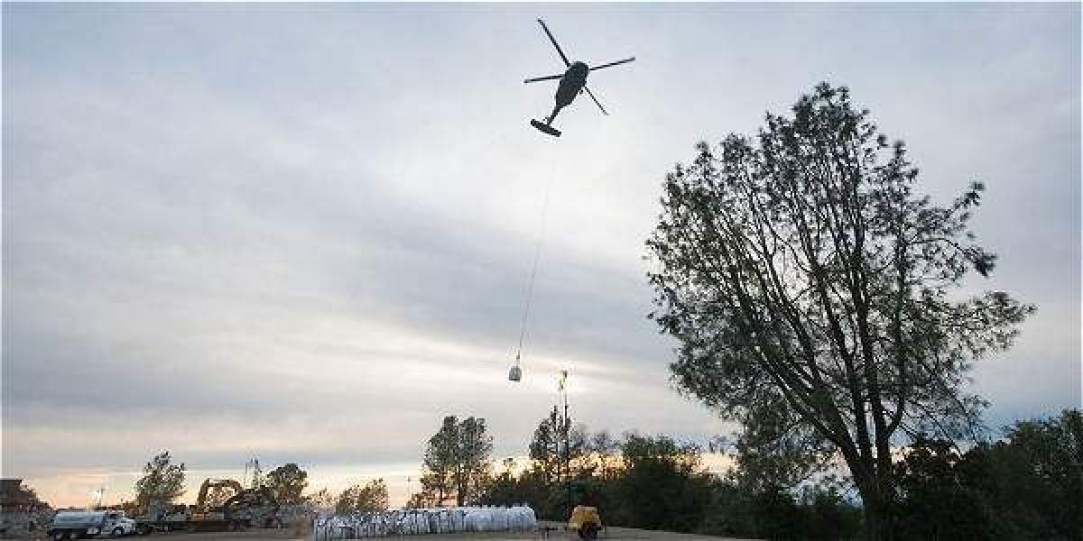 Un helicóptero transporta grandes bolsas de rocas desde un aparcamiento de Oroville al aliviadero auxiliar de la presa del lago en Butte County, California.