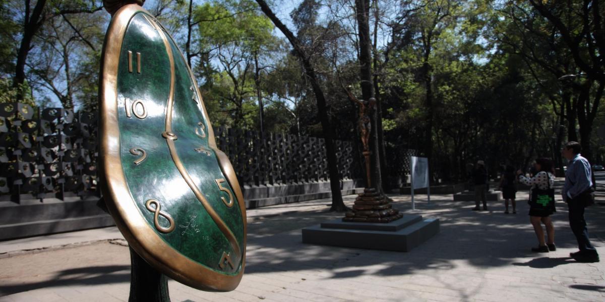 Visitantes caminan junto a la obra 'La danza del tiempo', del artista español Salvador Dalí en Ciudad de México.
