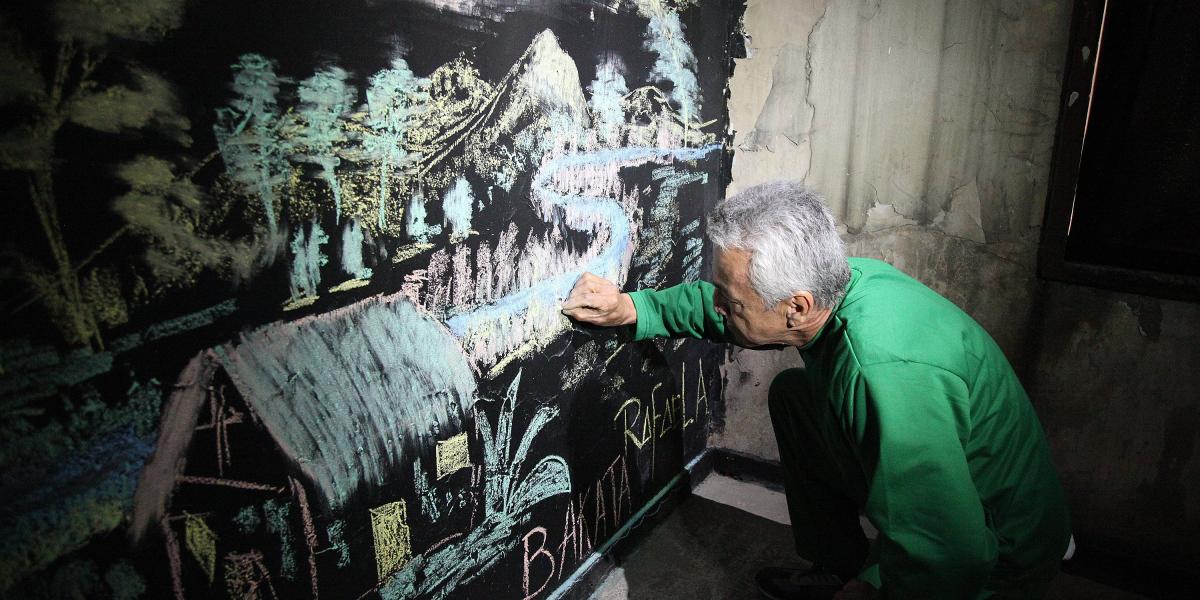 Rafael Arce pintó con tizas los paisajes que adornan 'Habitar mis historias' en la Escuela Taller de Bogotá.