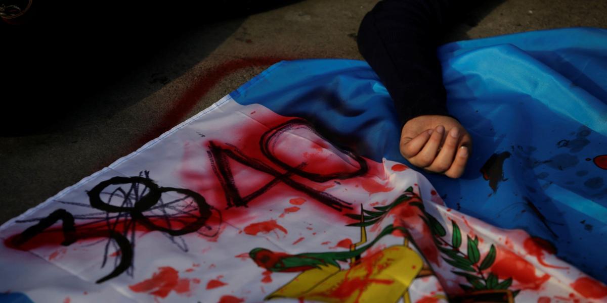 Manifestantes pintaron de rojo banderas guatemaltecas como símbolo de las decenas de muertes causadas por el incendio de esta semana.