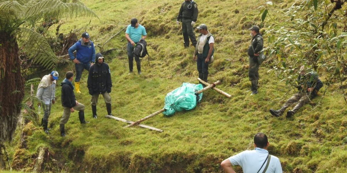 Momento en que policías y funcionarios de Corpoguavio recogen el oso muerto.