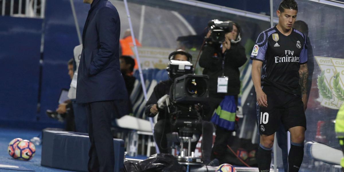 James Rodríguez, pasa por detrás del técnico francés Zinedine Zidane, tras ser sustituido durante el encuentro Alavés y Real Madrid, en el estadio de Butarque. El volante colombiano salió furioso.