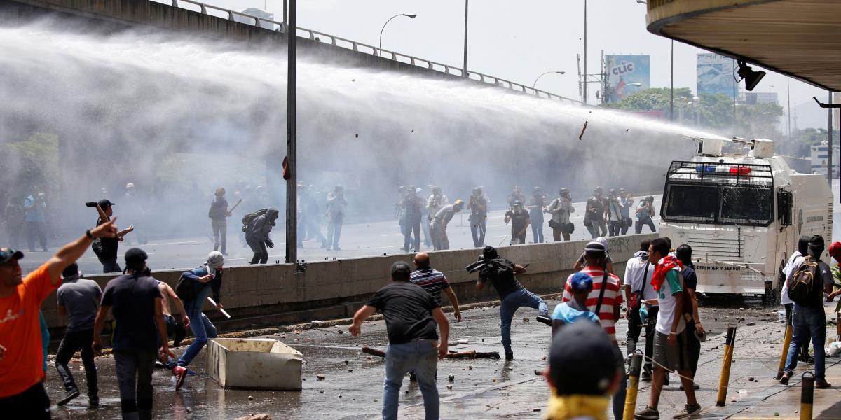 Opositores que marchan en Venezuela se enfrentan con la Guardia Nacional en las calles de Caracas.