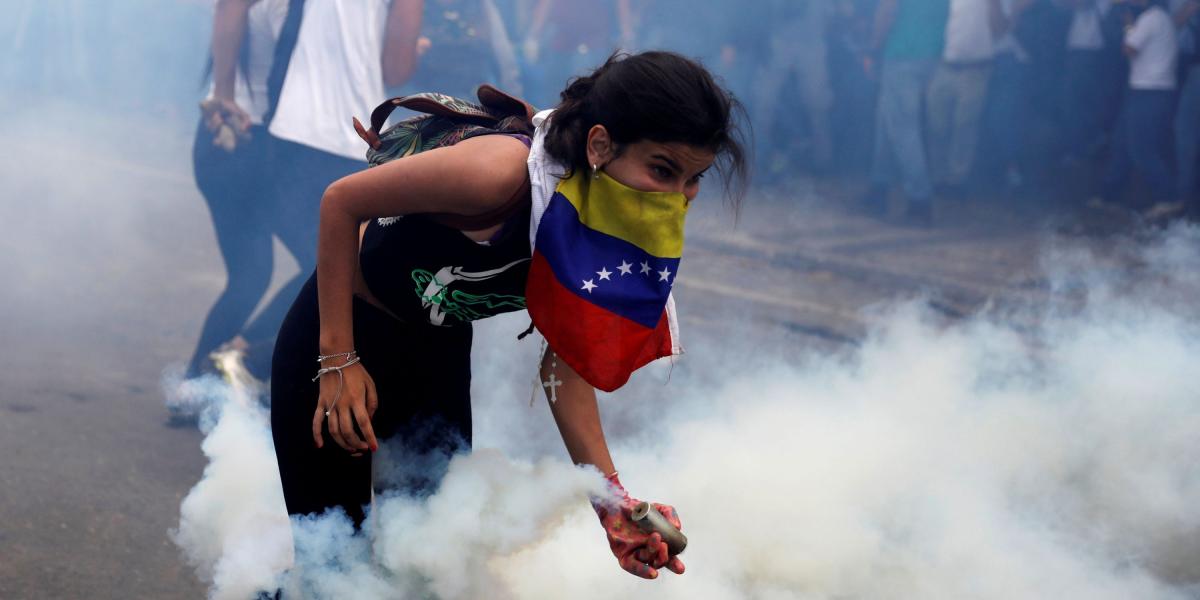 Miles de venezolanos salieron a protestar ayer contra el régimen de Maduro. Aquí, una opositora toma una lata de gas lacrimógeno.