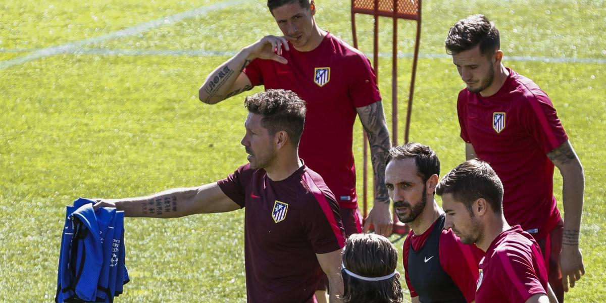 El entrenador del Atlético de Madrid, Diego Simeone (izq.), da instrucciones a Fernando Torres (izq. arriba) y Saúl Ñíguez (der., arriba), entre otros, durante el último entrenamiento, previo al juego contra el Leicester.