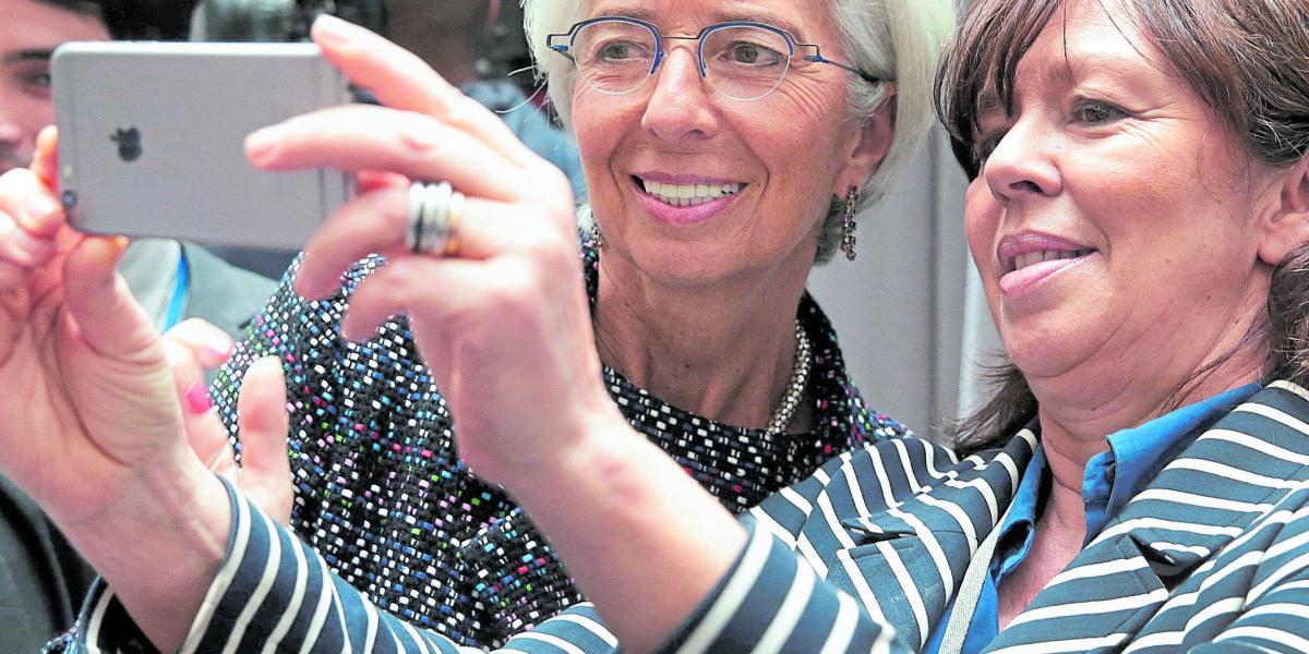 La gerente del FMI, Christine Lagarde (izq.), posa para una selfi con una visitante, tras uno de los foros, antes de la cumbre semestral del Fondo con el Banco Mundial.