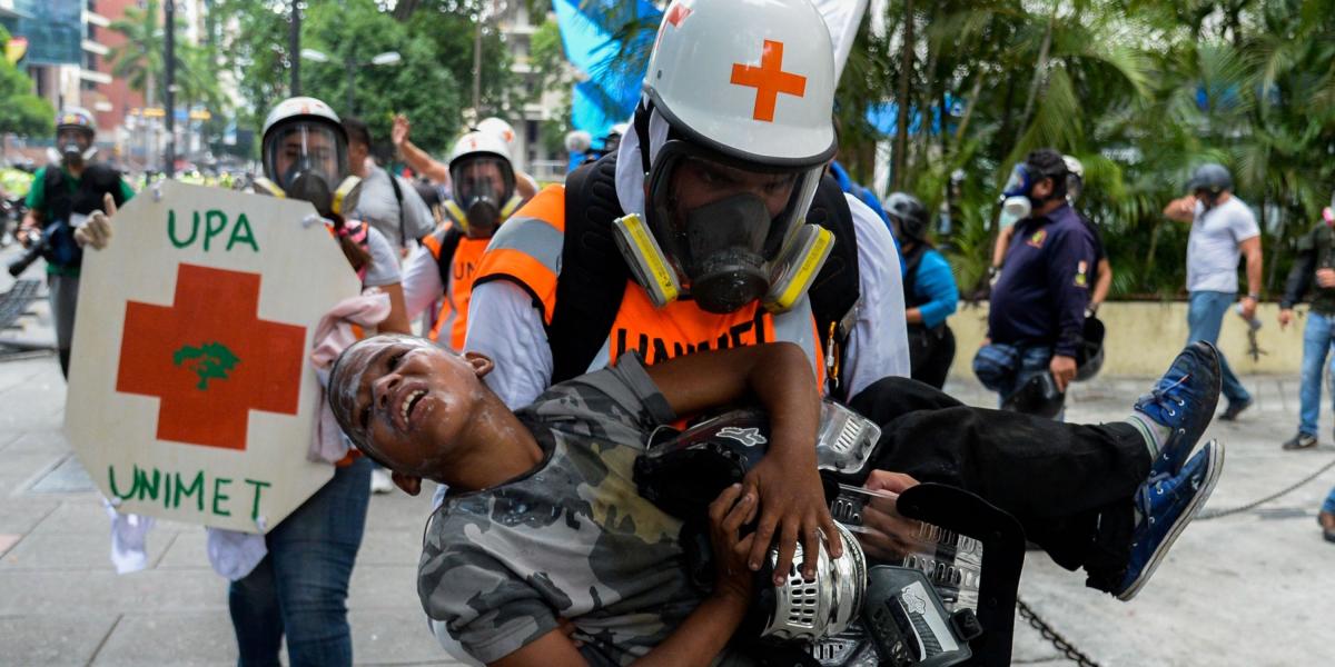 Personal médico atiende de urgencia a un niño que fue víctima de los gases lacrimógenos.