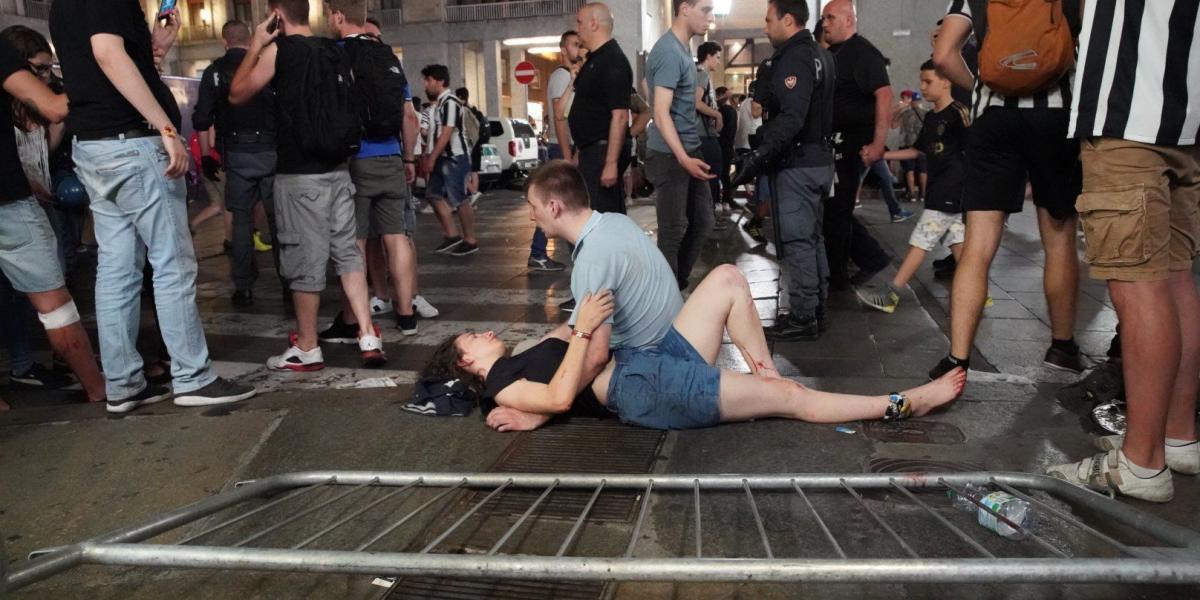 Un hombre atiende a una mujer herida en la Plaza de San Carlo, en Turín.