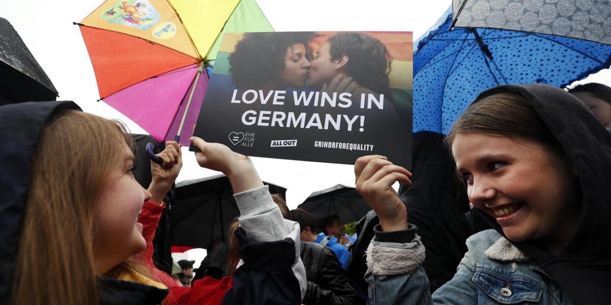 Varias personas celebran la aprobación de la legalización del matrimonio homosexual en el Parlamento ante la Cancillería en Berlín (Alemania).