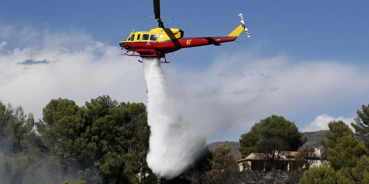 Un helicóptero se suma a las labores de extinción de un incendio en Carros, cerca de Niza, al sur de Francia.