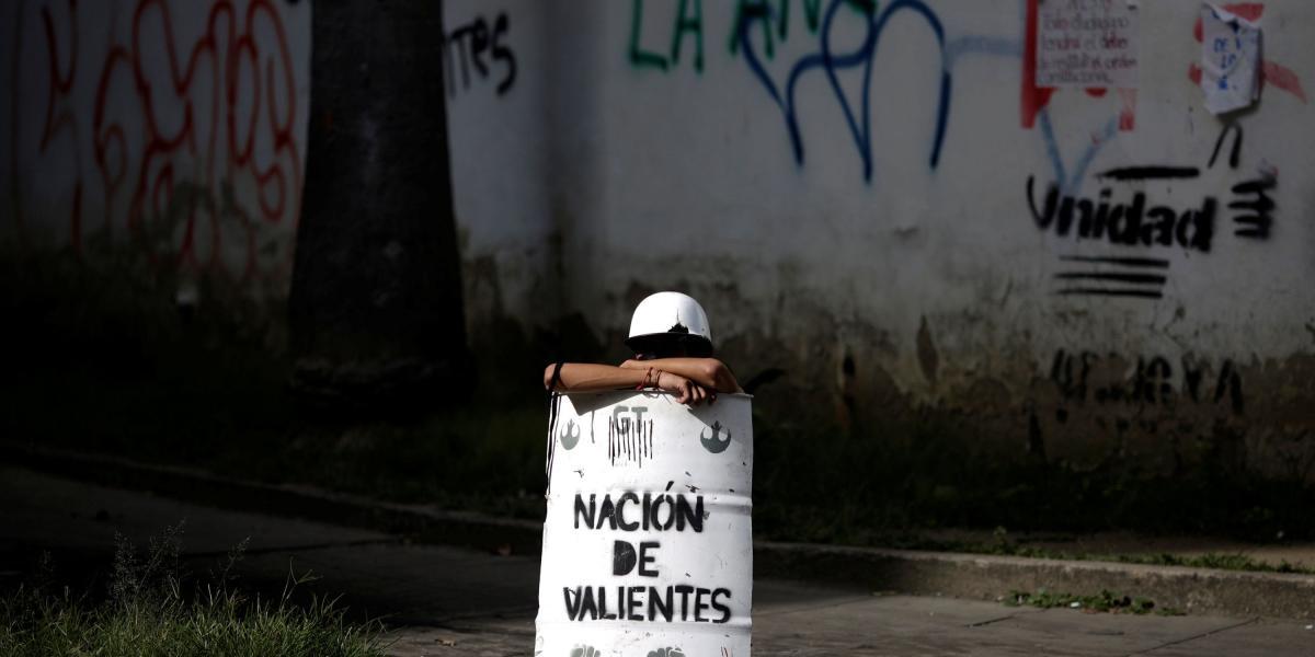 Manifestante utiliza un escudo improvisado que dice "Nación de los valientes" para protestar contra el gobierno de Nicolás Maduro en Caracas.