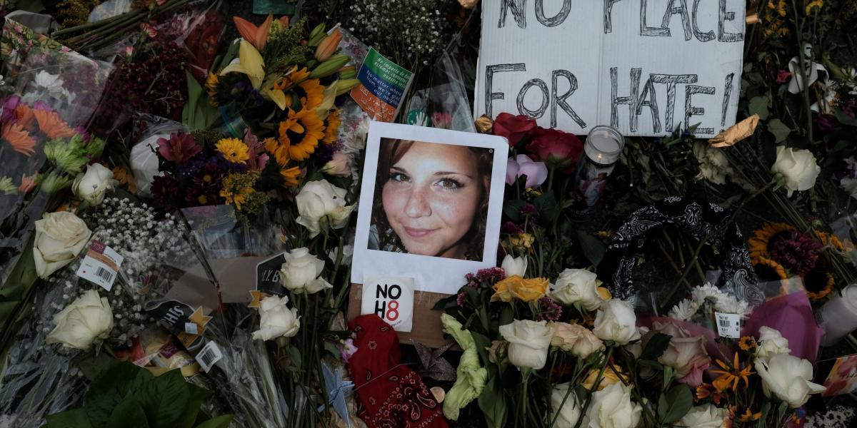Fotografía de Heather Heyer, víctima del atentado en Charlottesville, Virginia, en medio de flores y letreros de repudio a la violencia.