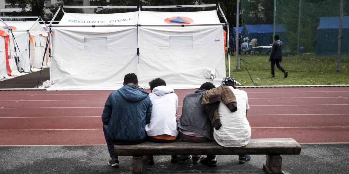 Varios inmigrantes sentados en frente de sus tiendas de campaña colocadas en un campamento temporal situado en el XV distrito de París.