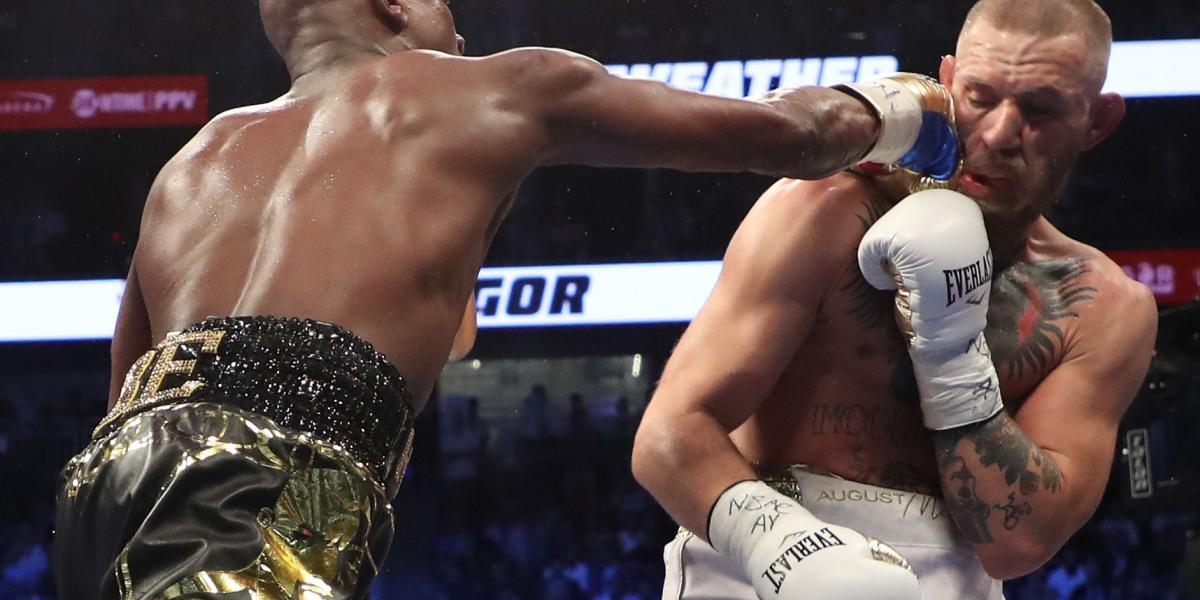 Mayweather asesta un golpe a McGregor durante la publicitada pelea del año, este sábado en Las Vegas.