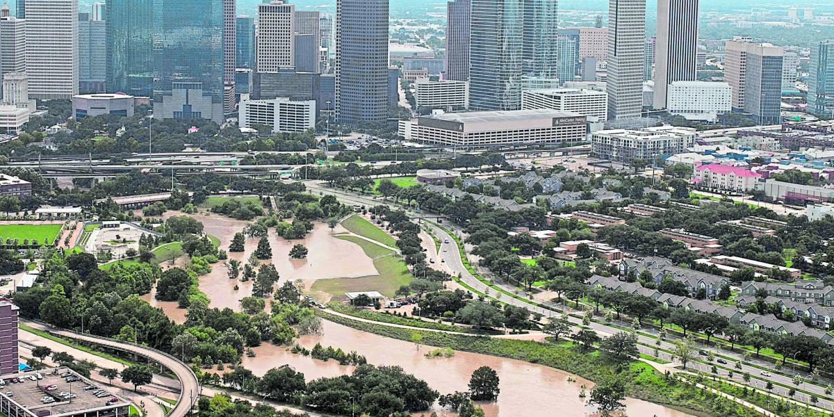 Áreas inundadas y, atrás, el perfil de la ciudad estadounidense de Houston, luego del paso del huracán Harvey.