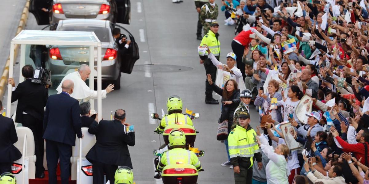 Papa Francisco saluda a los feligreses que lo esperan durante su recorrido por la calle 26.