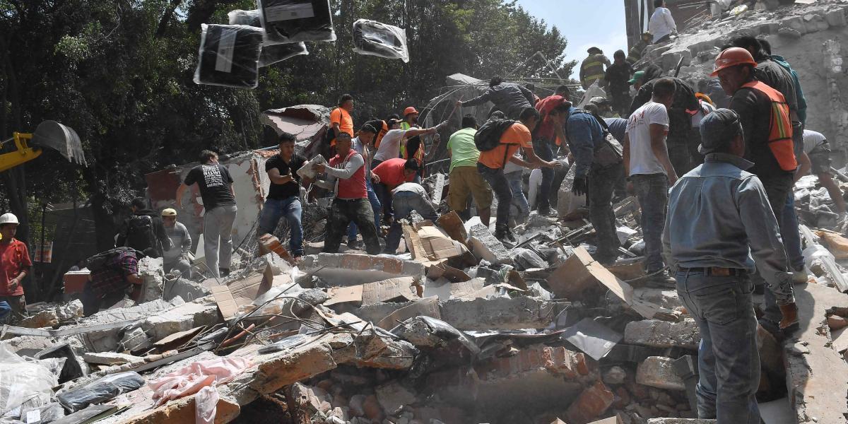 Personas remueven escombros en busca de víctimas tras el colapso de un edificio en Ciudad de México.