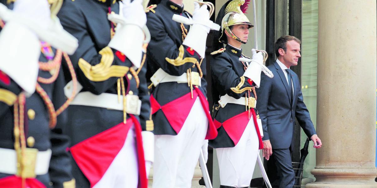 El presidente de Francia, Emmanuel Macron (der.), en la entrada del palacio presidencial del Elíseo.