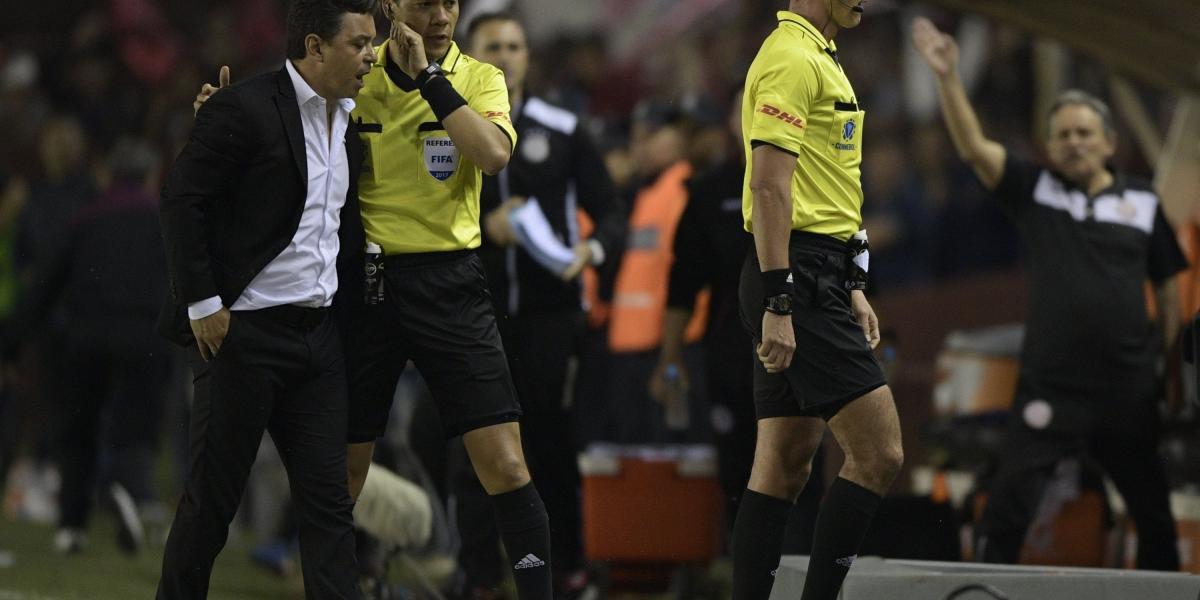 El árbitro colombiano Wilmar Roldán recibió la protesta del DT de River Plate Marcelo Gallardo (izq.), tras el final del partido que deparó la eliminación del equipo de la banda roja.