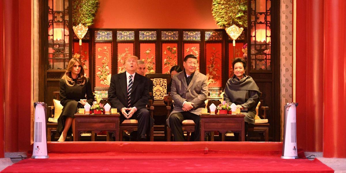 El presidente de los Estados Unidos, Donald Trump, levanta la vista mientras se sienta junto a la Primera Dama, Melania Trump, y el Presidente chino, Xi Jinping, y su esposa, Peng Liyuan, durante una gira por la Ciudad Prohibida.