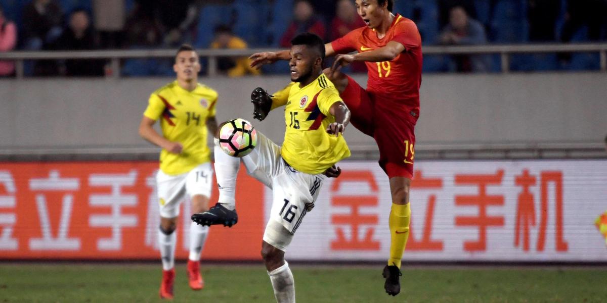 Miguel Borja (izq.) disputa el balón con Yin Hongbo (der.), durante un partido amistoso entre Colombia y China, que se disputó en Chongqing (China). El colombiano marcó dos goles en el triunfo 4-0.