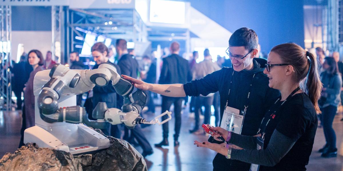En Slush 2016, la feria de ‘start ups’ más grande de Finlandia, dos asistentes ven en acción un robot funcionando con 5G, en Helsinki.