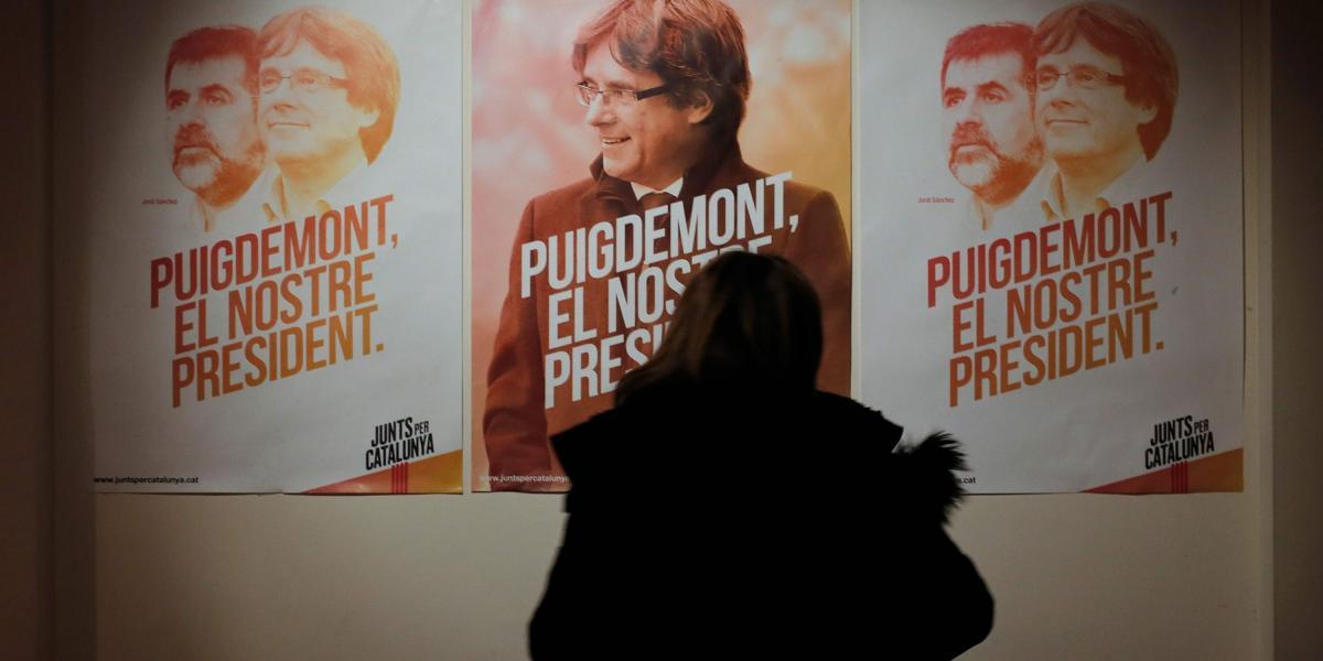 Una mujer observa los carteles electorales durante la presentación del programa del grupo catalán pro independencia, 'Junts Per Cataluña.