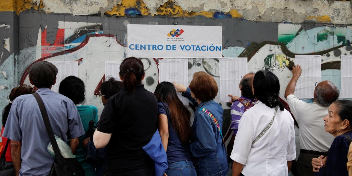 Gente mirando las listas en un centro de votación en Maracaibo, Venezuela.