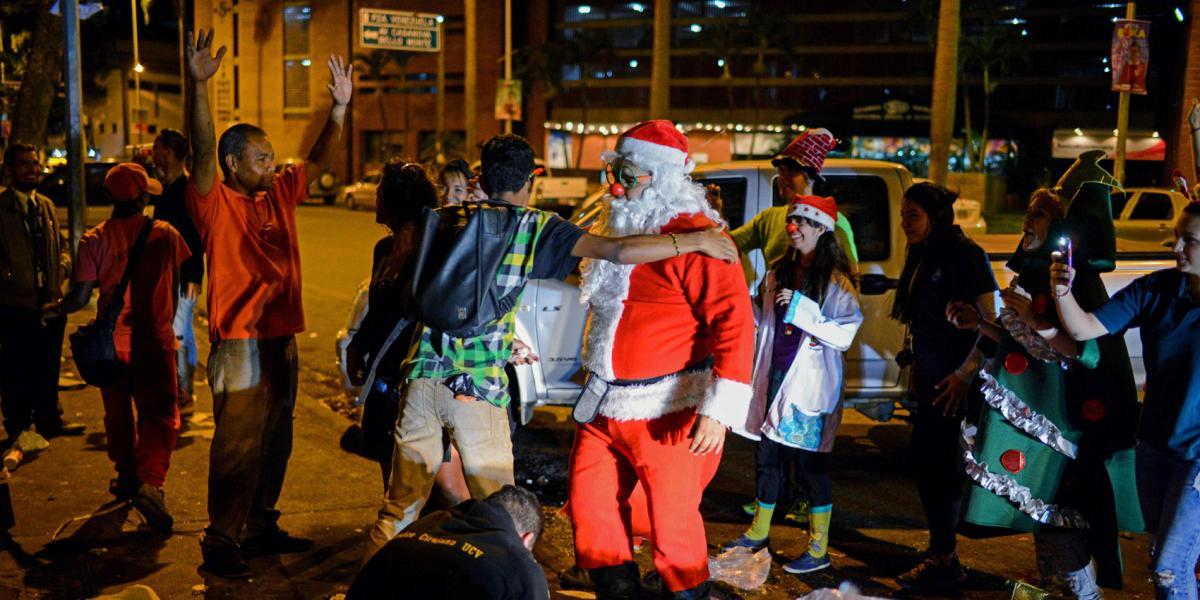 Un Papá Noel encabeza un grupo que intenta llevar algo de alegría a un sector deprimido de Caracas donde abundan 
los indigentes.