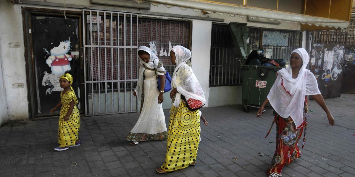Emigrantes cristianos eritreos africanos caminando afuera en una iglesia improvisada en el sur de Tel Aviv.