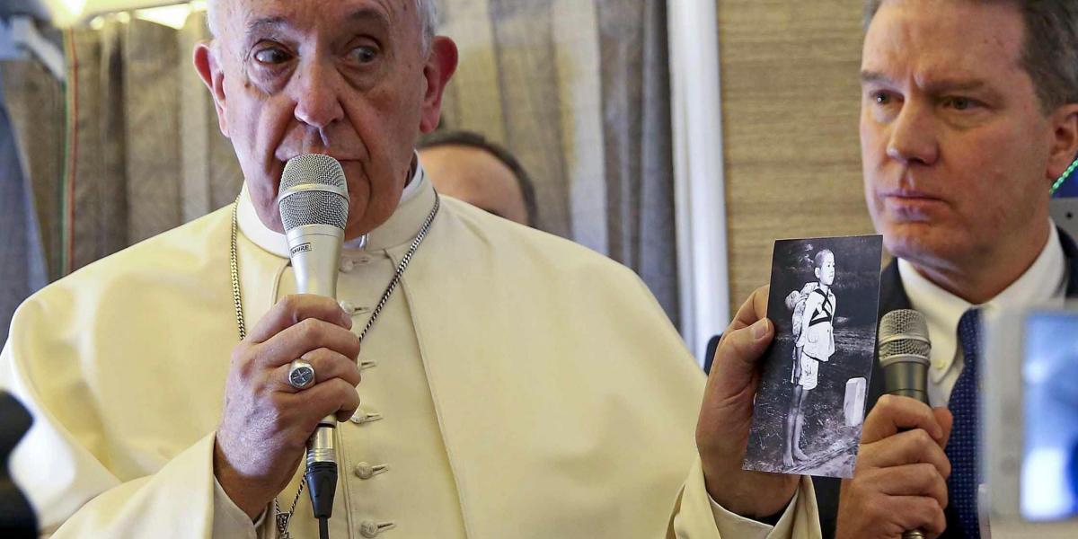 El papa Francisco sostiene una fotografía de una víctima de Nagasaki durante una charla con periodistas a bordo del vuelo hacia Chile este lunes.