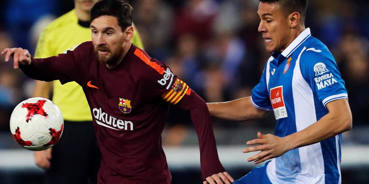 El delantero argentino del FC Barcelona Lionel Messi (izq.) disputa el balón con el defensa nicaragüense Óscar Duarte, del Español, durante el partido de ida de los cuartos de final de Copa del Rey que disputó en el RCD Stadium.